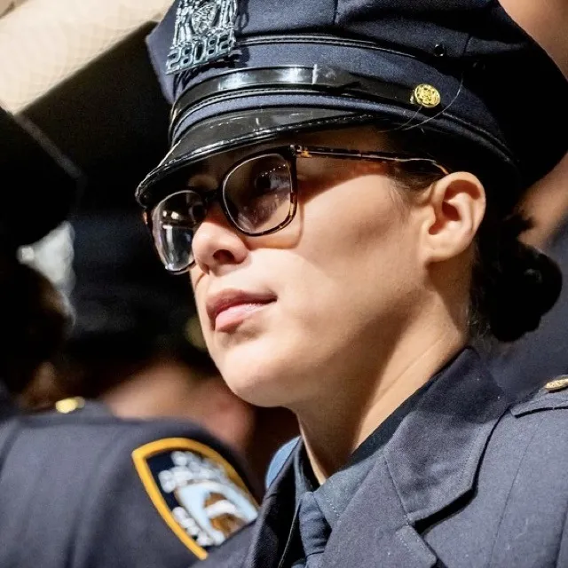 A female police officer, Yuleni A. Campossaavedra, wearing glasses and a uniform.