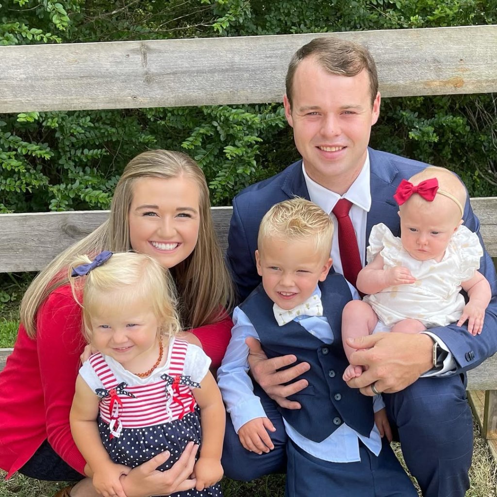 Joseph Duggar, Kendra Caldwell, and their three children smile at the camera.