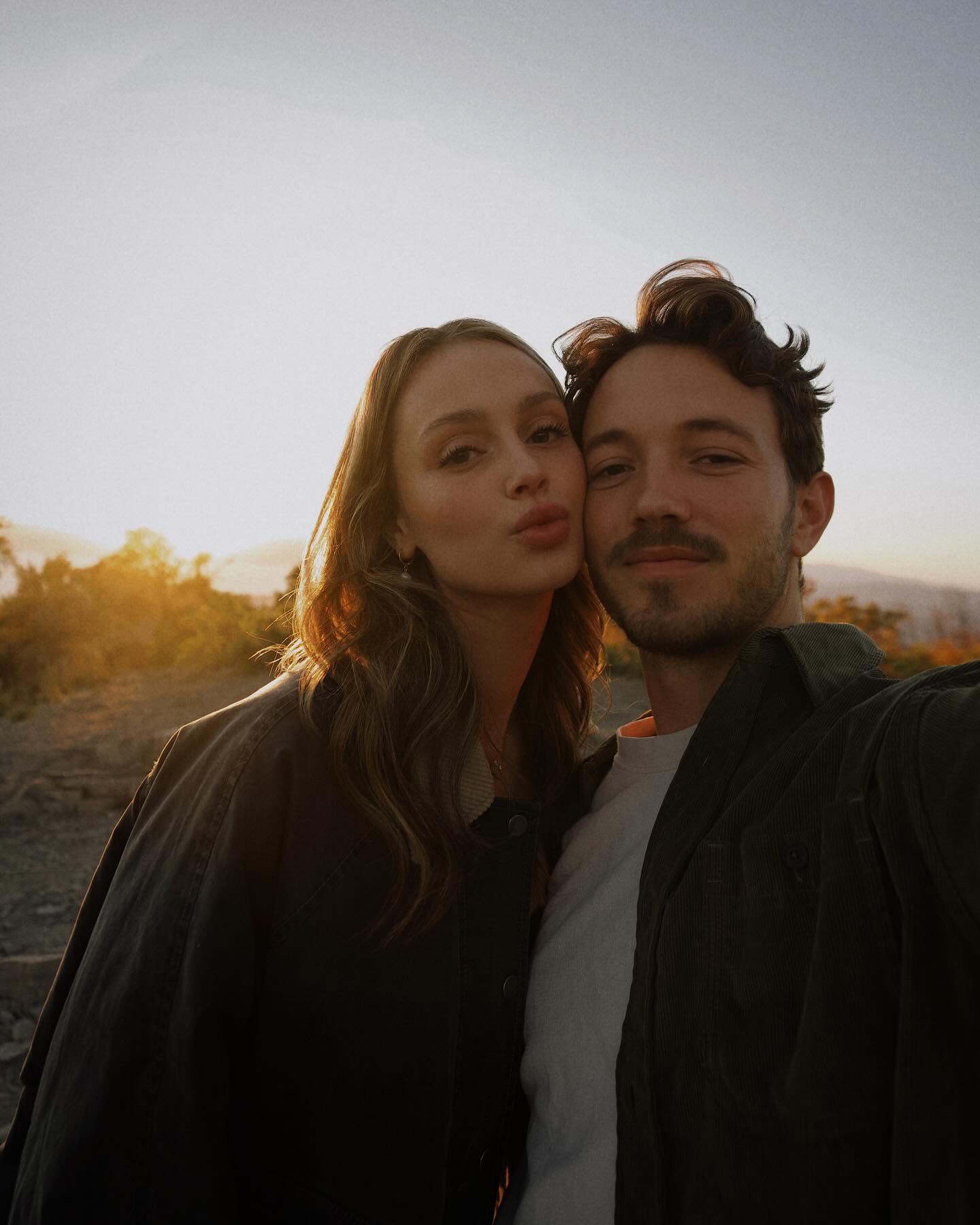Matthews and Terry, a woman and man, taking a selfie at sunset.