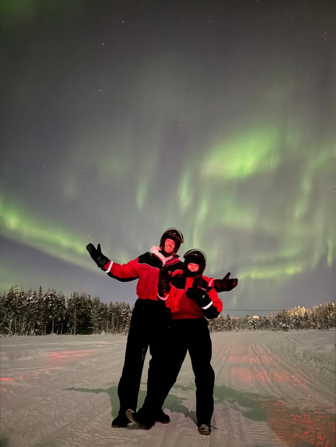Chelsea Handler and a companion posing in front of the Northern Lights.