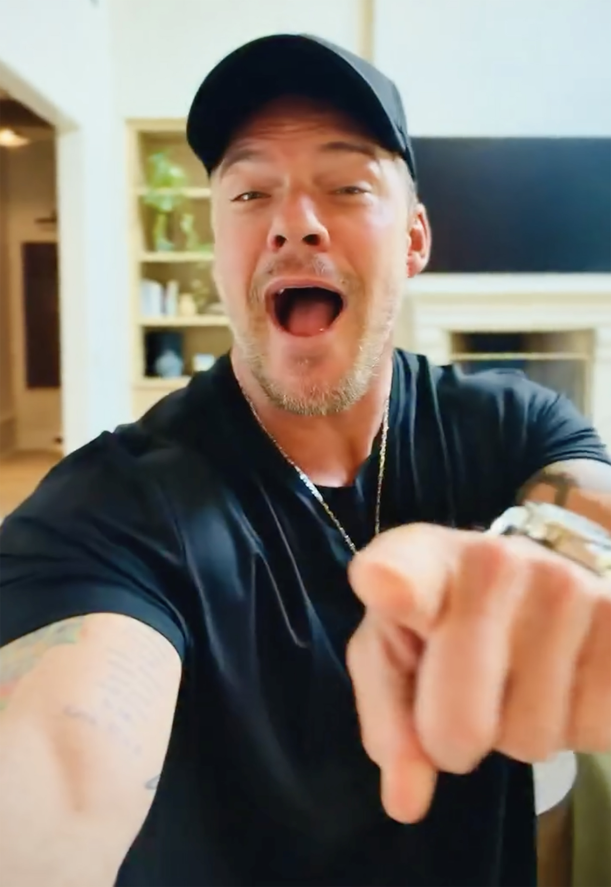 Alan Ritchson laughing off haters post-brawl, pointing at the camera.