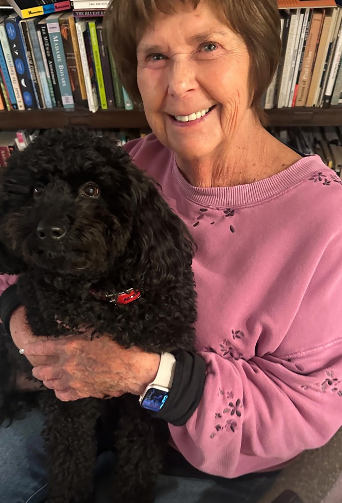 Nancy Guthrie, mother of Savannah Guthrie, holds a black poodle and smiles.
