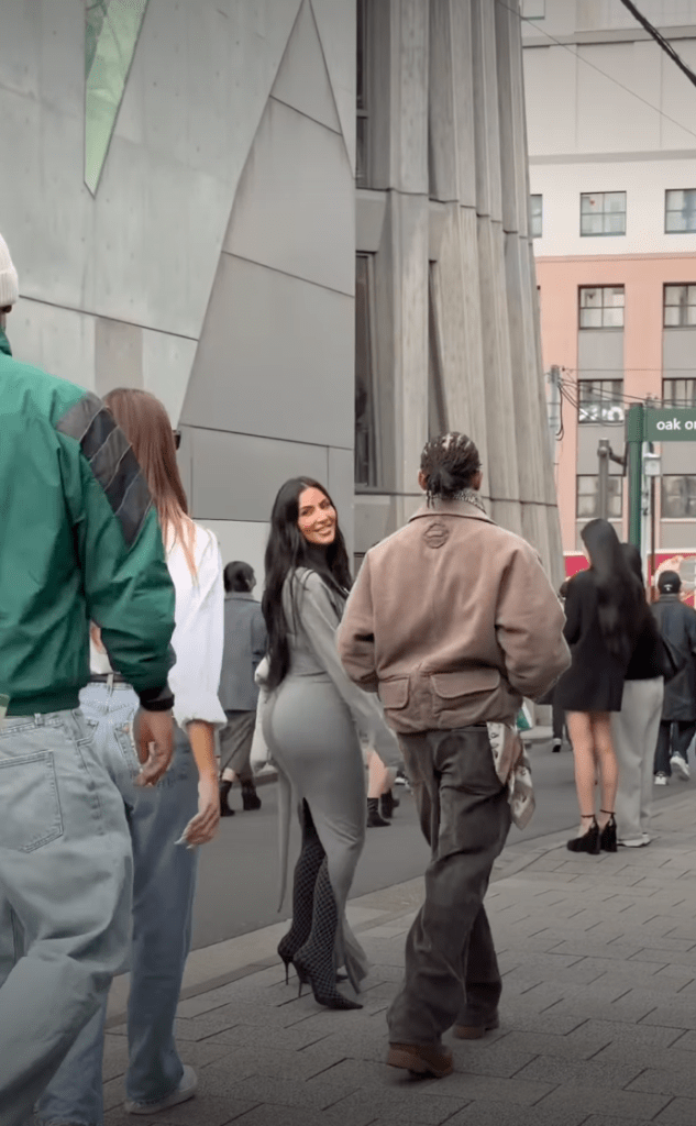 Kim Kardashian and Lewis Hamilton shopping in Tokyo, with Kardashian looking over her shoulder at the camera.