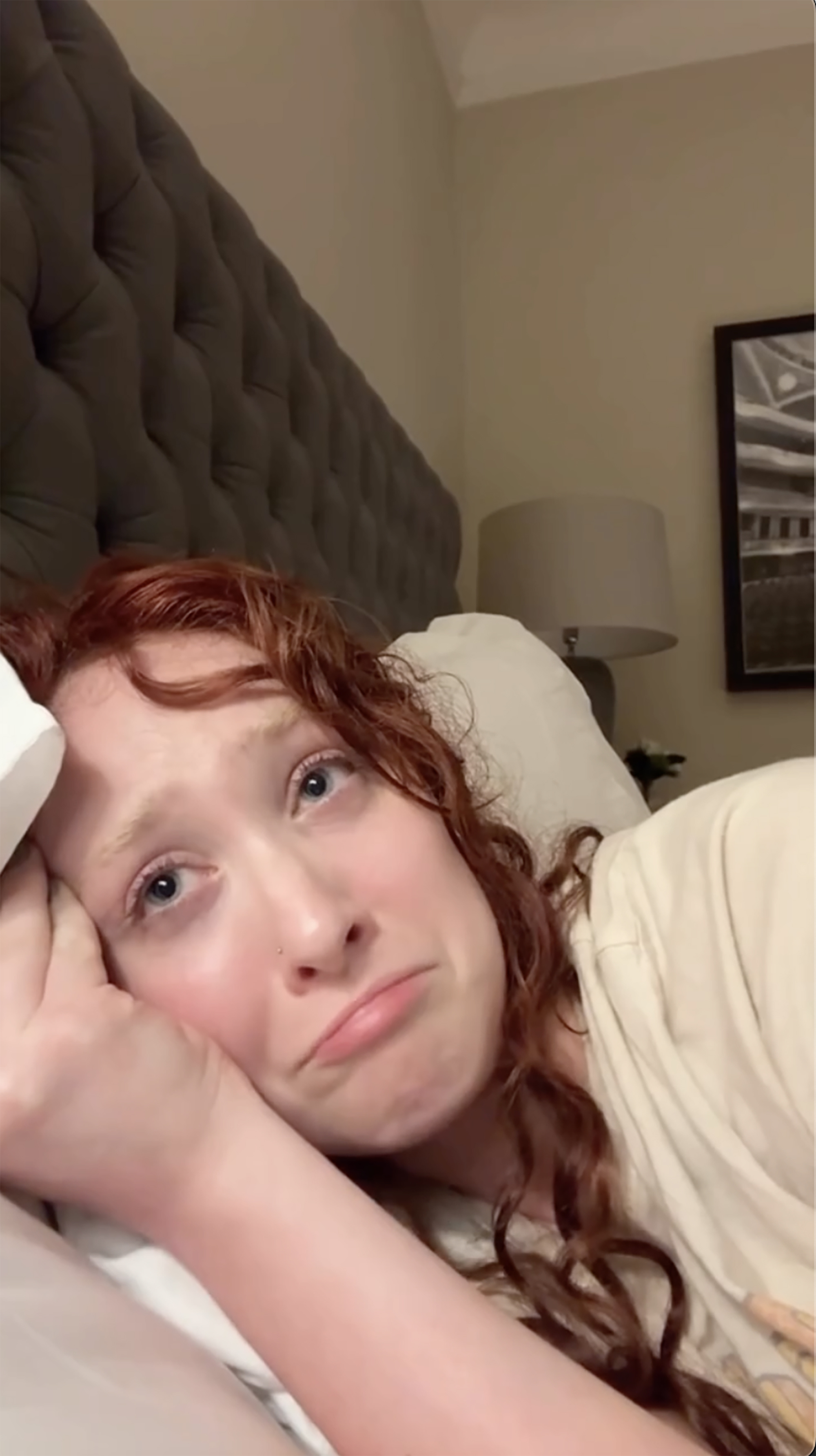 Chappell Roan looking distressed while lying in bed.