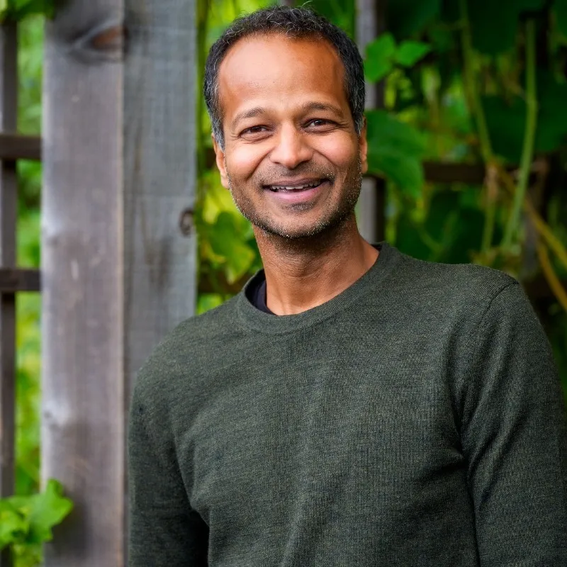 Soups Ranjan smiling in a dark green sweater.