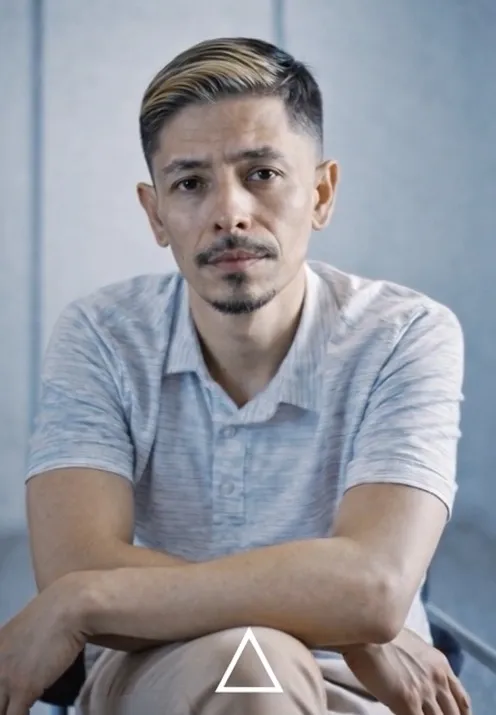 Rene Campos for District 7, with light-colored hair and a mustache and beard, sitting with arms crossed.