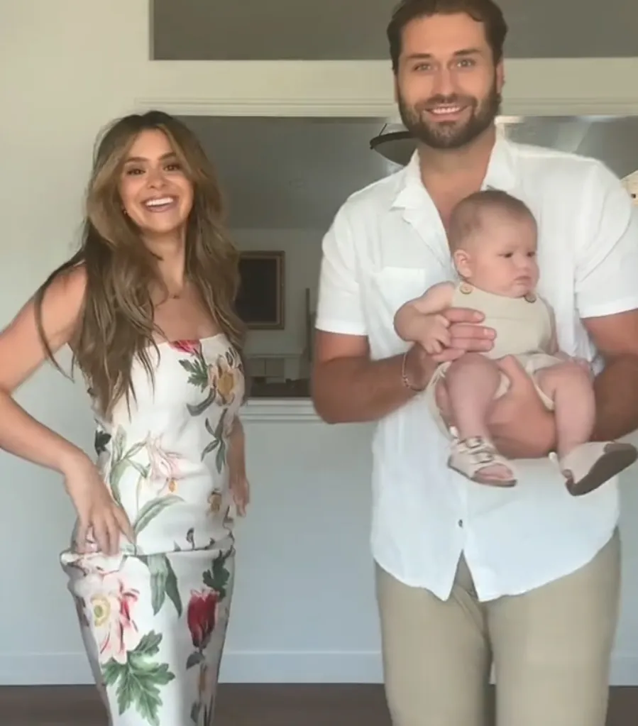 Taylor Frankie Paul smiling in a floral dress, standing next to Dakota Mortensen holding a baby.