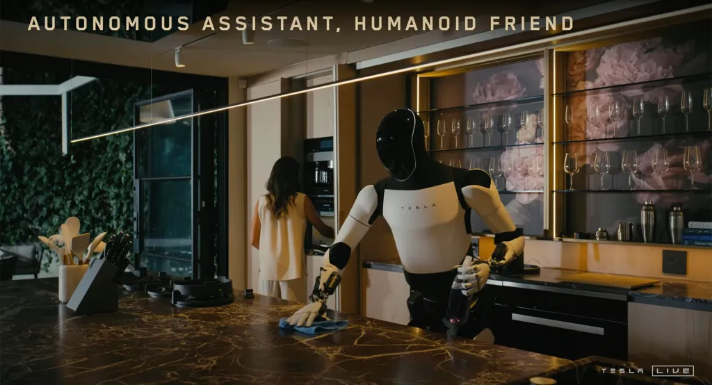 Tesla robot cleaning a kitchen counter with a woman in the background.