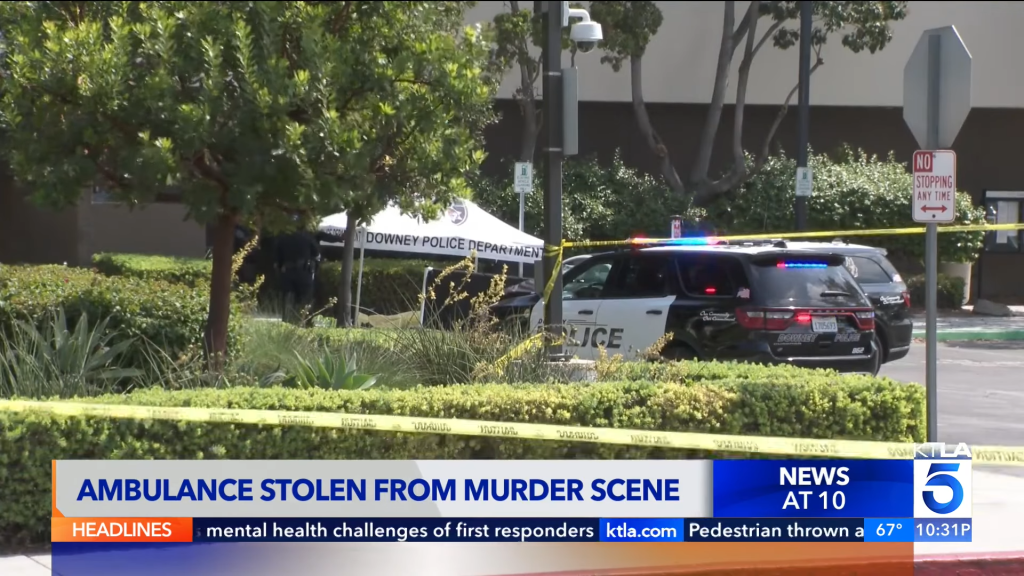 Police vehicles and crime scene tape at the location of a murder.