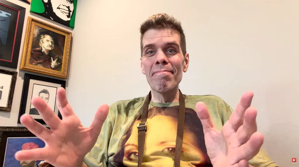 Perez Hilton gestures with his hands towards the camera.