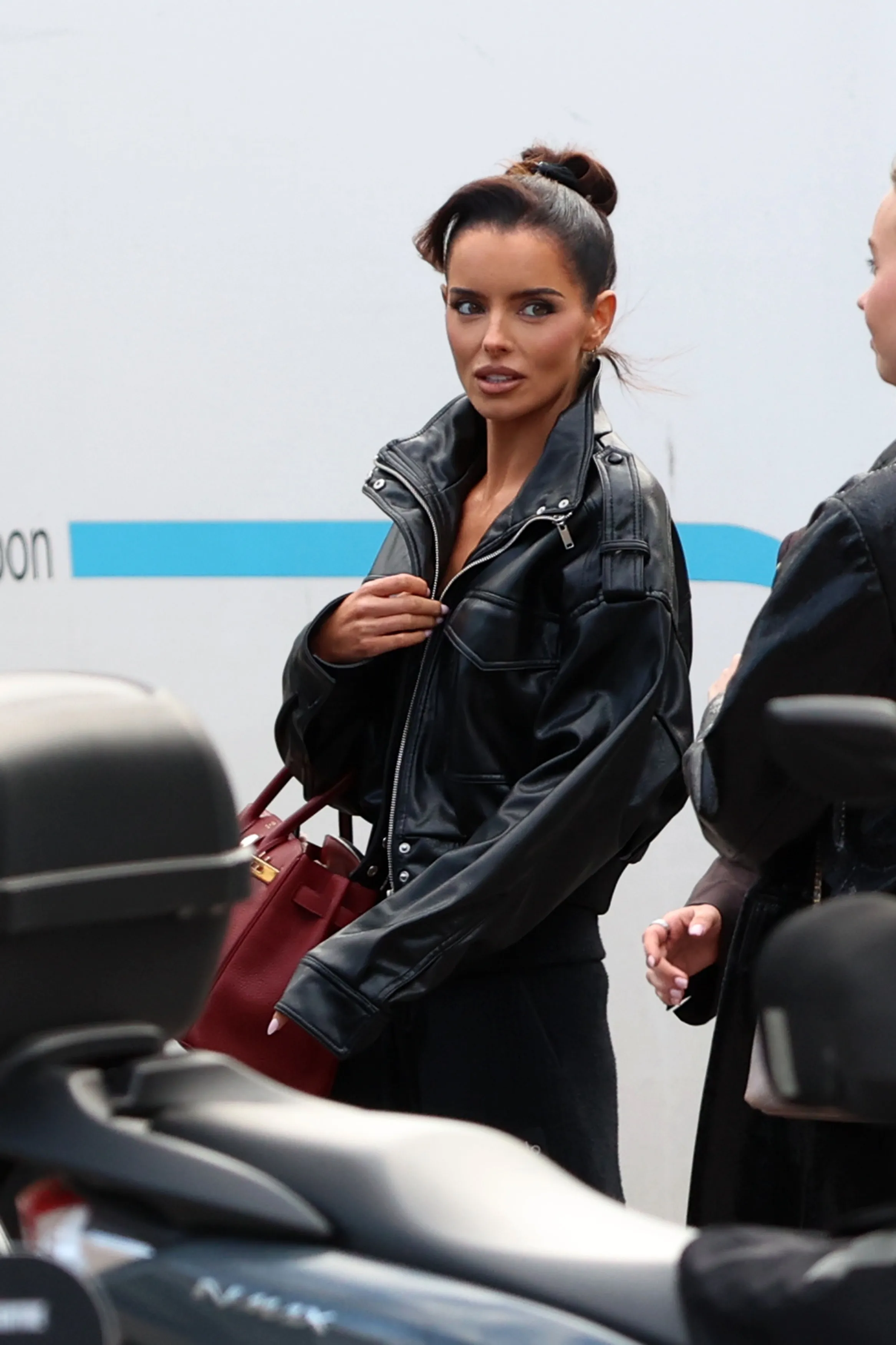 Maura Higgins in a black leather jacket, carrying a red Hermès Birkin bag.