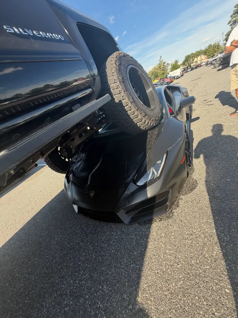 A pickup truck on top of a Lamborghini Huracan.