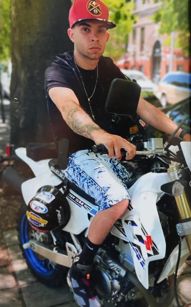 Eric Duprey sitting on a Suzuki motorcycle.