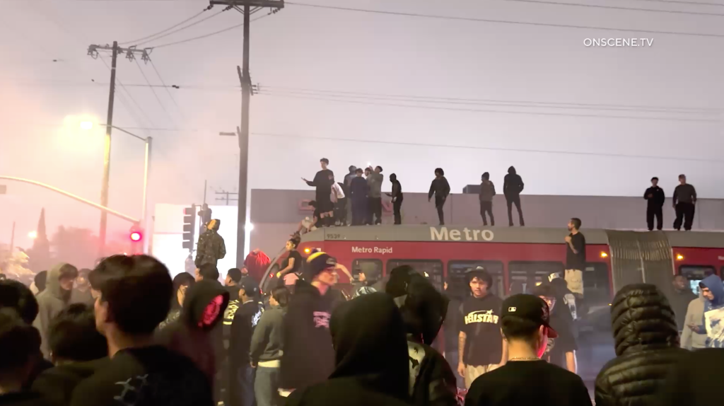 People standing on a Metro Rapid bus during a street takeover.