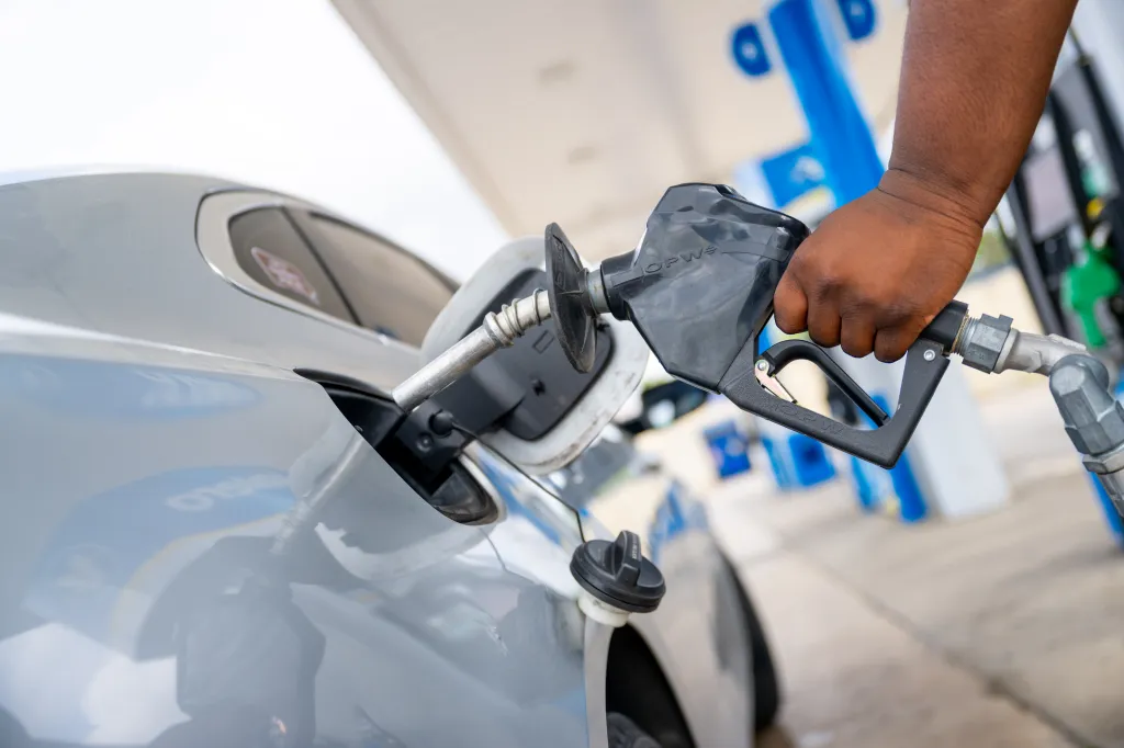 A person pumping gas into a car at a Valero gas station.