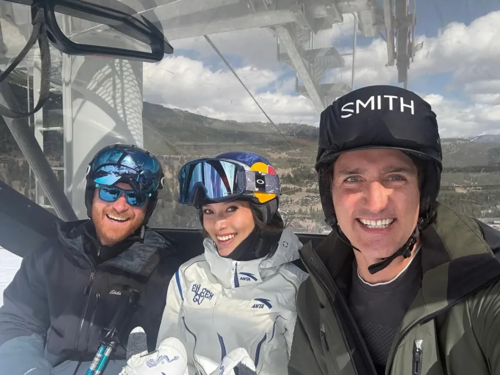 Three skiers, including Justin Trudeau and Eileen Gu, posing for a selfie in a gondola.