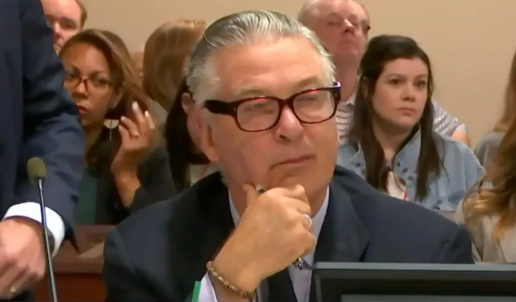 Alec Baldwin with a pen in his hand, observing the courtroom proceedings.