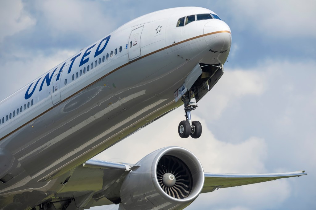 United Airlines Boeing 777-300ER with its landing gear extending.