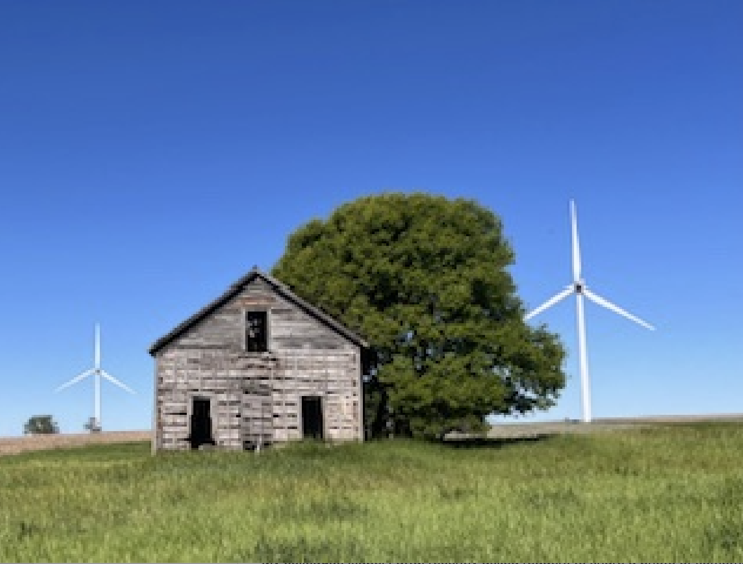 Wooden house with wind power mills next to it
