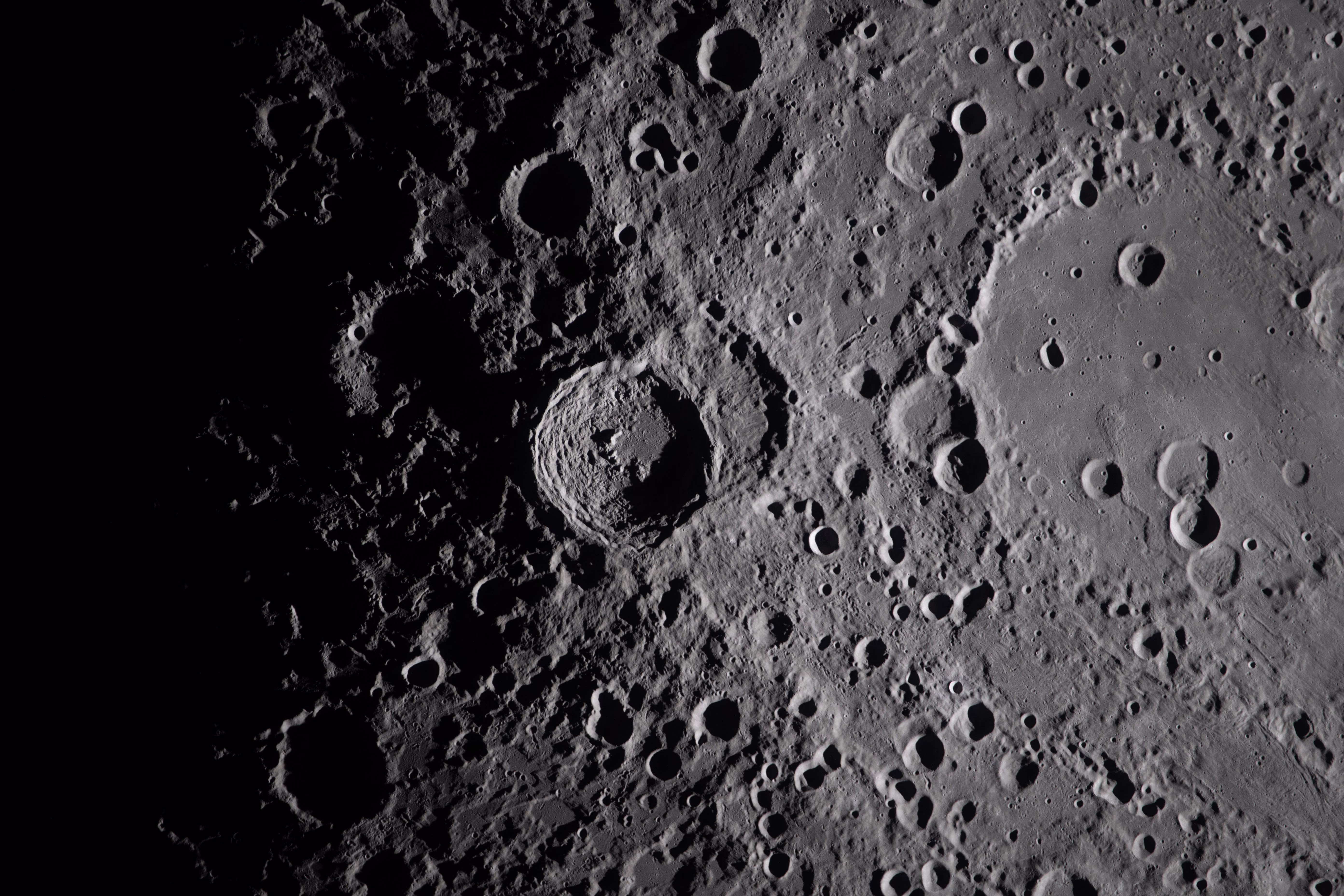 A close view of many rugged craters on the moon's surface.
