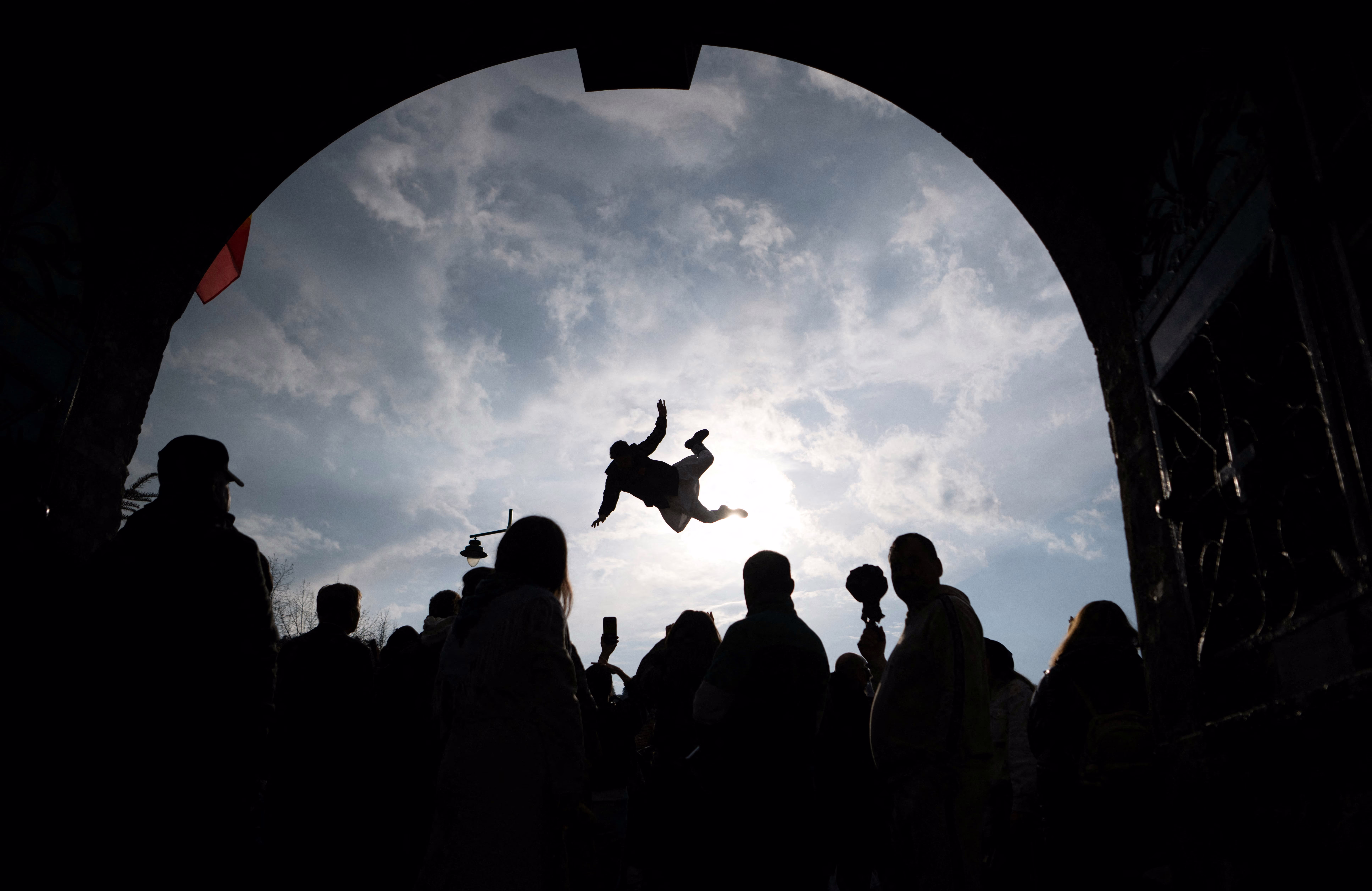 A person is tossed into the air by others using a rug during a festival.