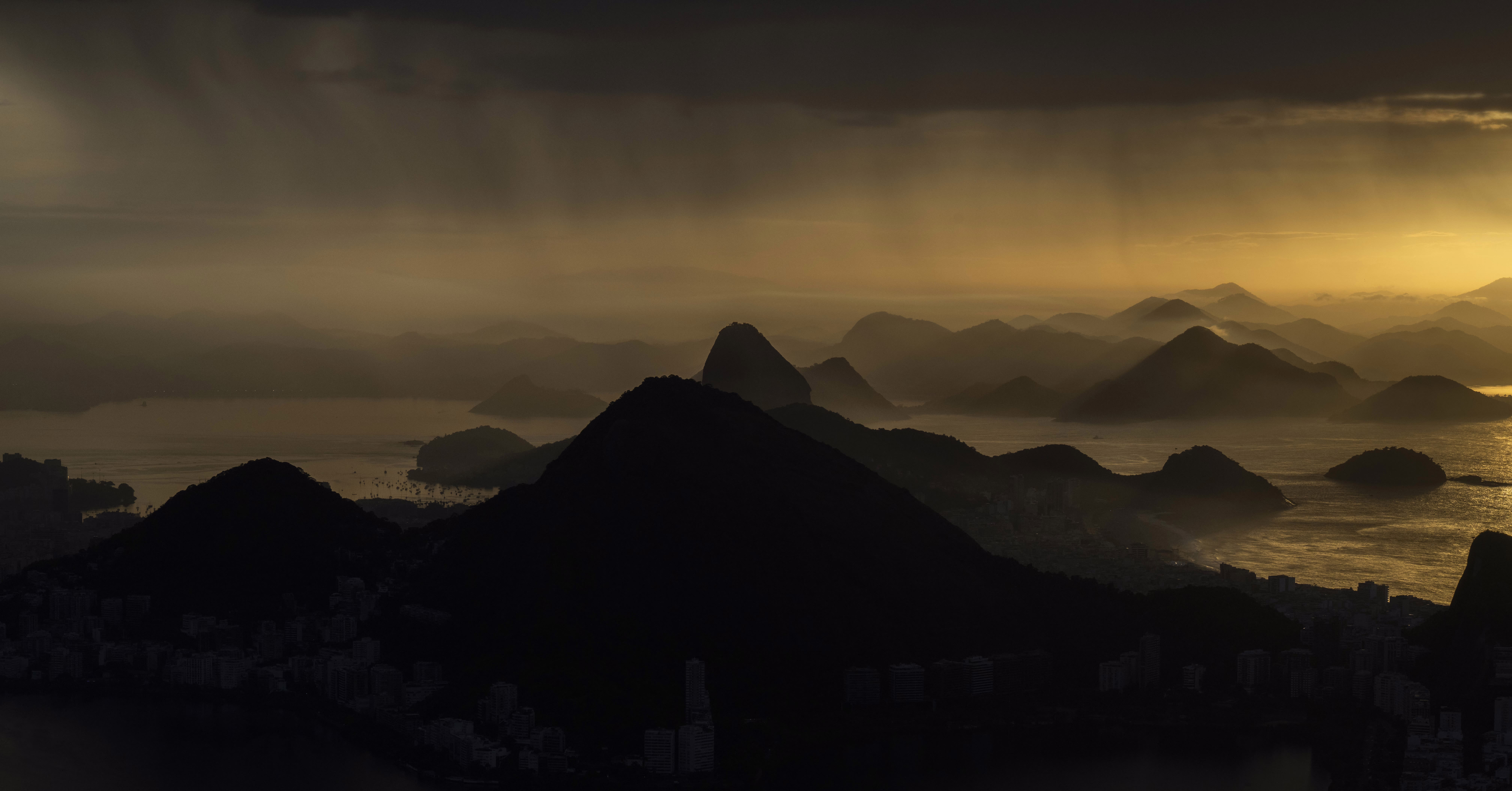 A panoramic sunrise view of a bay during a rainy morning in Rio de Janeiro.