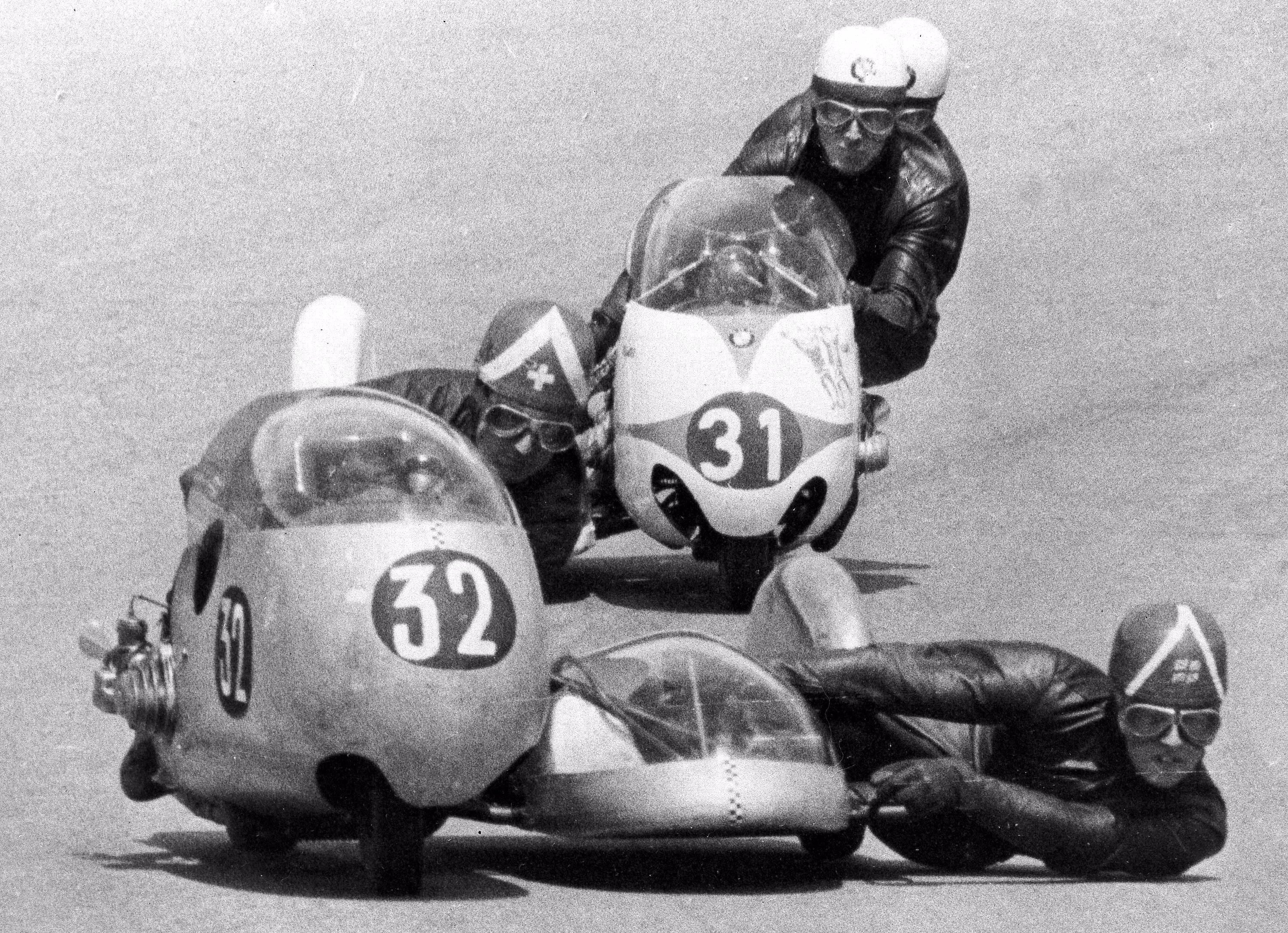 Two motorcycle-and-sidecar racers lean into a turn in 1950
