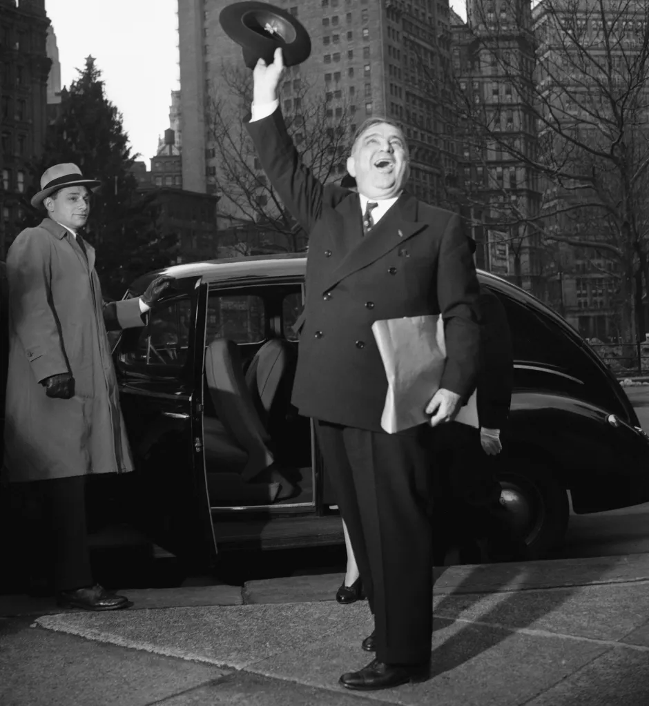 Former New York Mayor Fiorello LaGuardia waving his hat and saying farewell to friends.