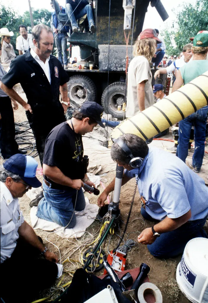 Rescue team members working to free 18-month-old Jessica McClure from a well pipe.