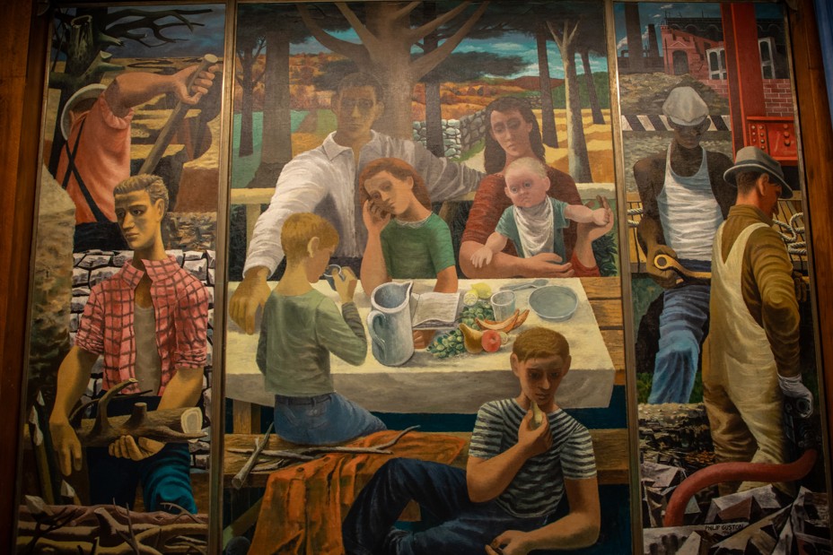 photo of 3-part mural painting with family at table flanked by images of people working