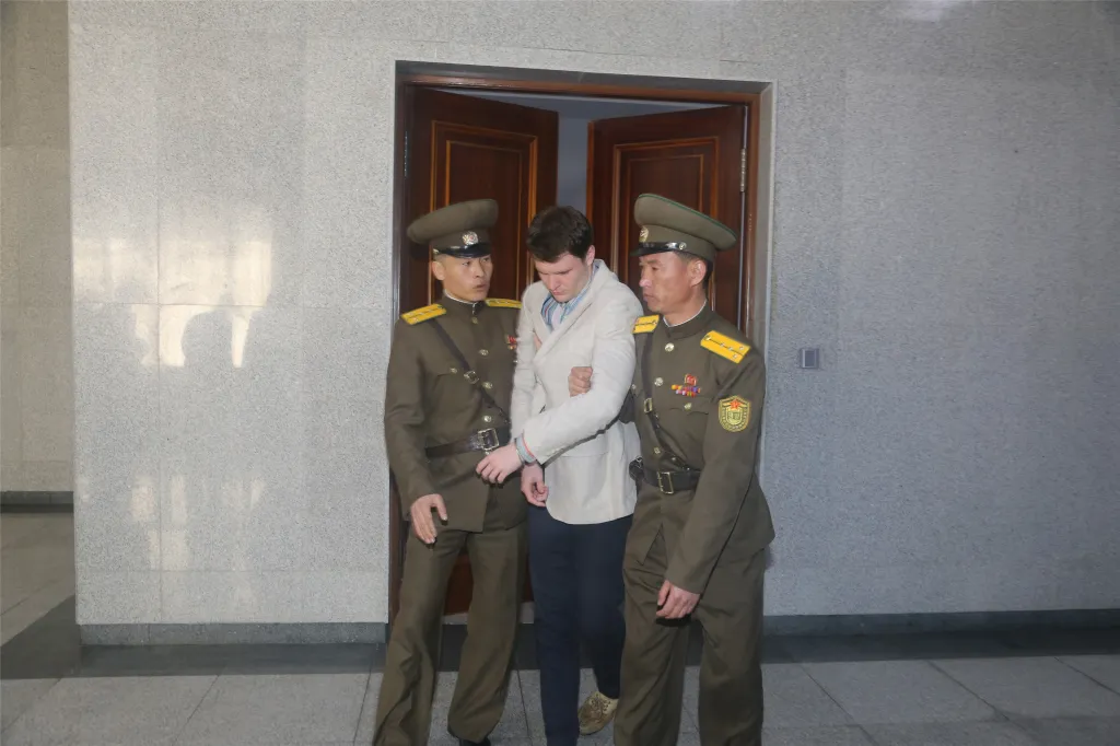 North Korean officials escort American prisoner Otto Warmbier after his trial in Pyongyang on March 16, 2016.