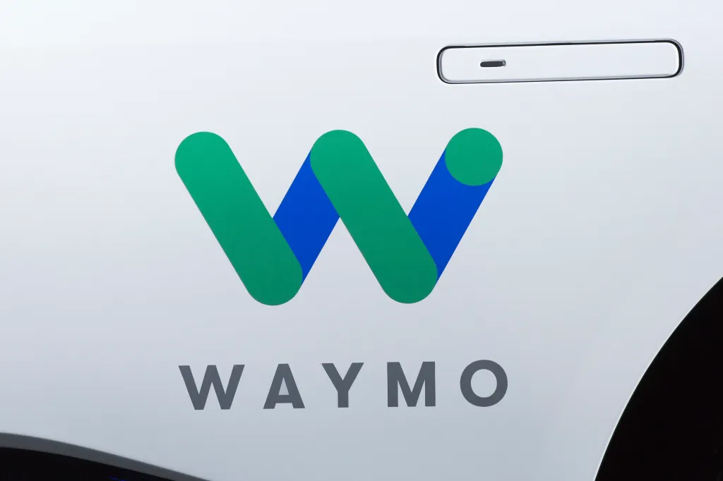 The Waymo logo on a white vehicle.