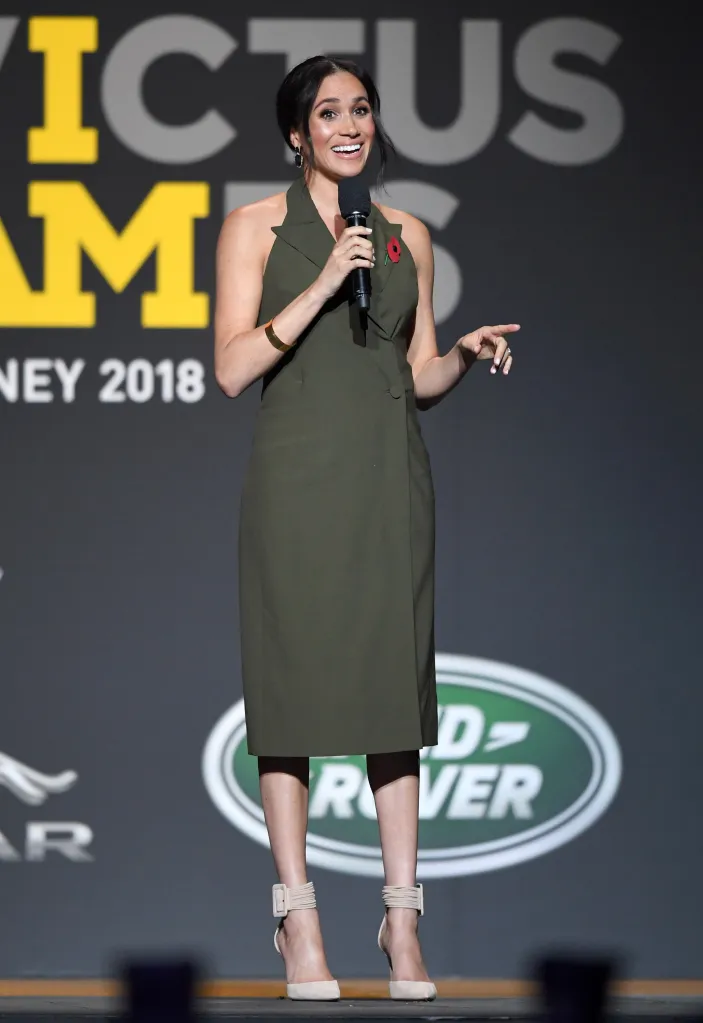 Meghan, Duchess of Sussex, in a dark green dress, speaks into a microphone at the Invictus Games Closing Ceremony in Sydney.