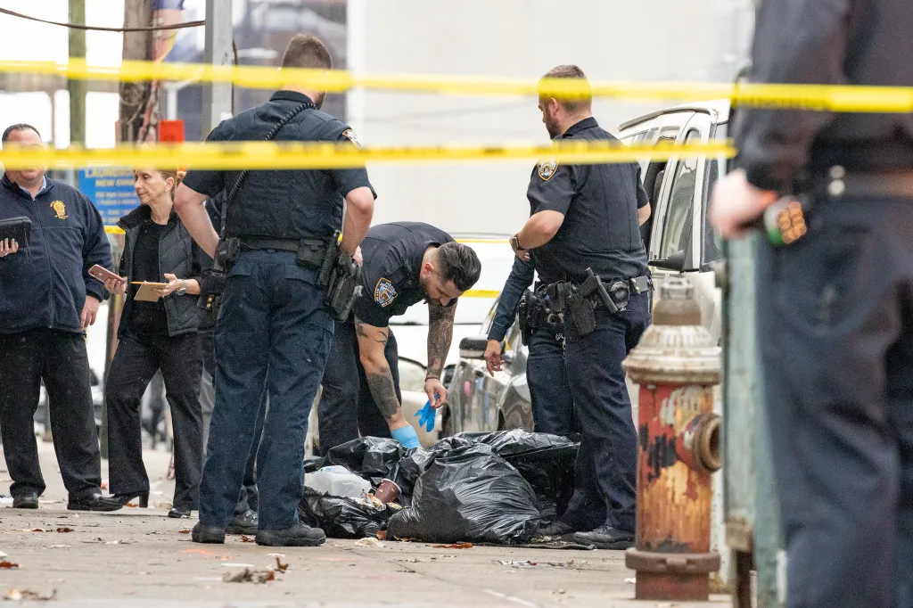 NYPD officers investigate discarded body parts in black trash bags on a Brooklyn street.