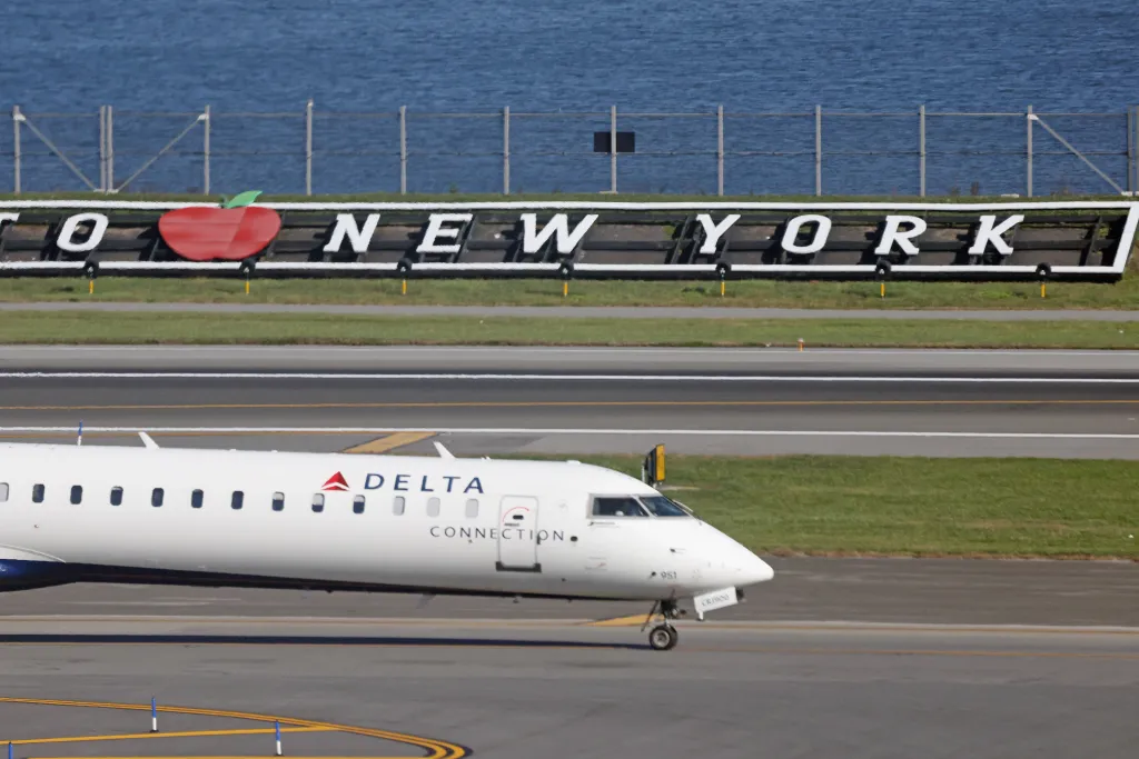 A Delta Airlines jet on the runway at LaGuardia Airport, with a 