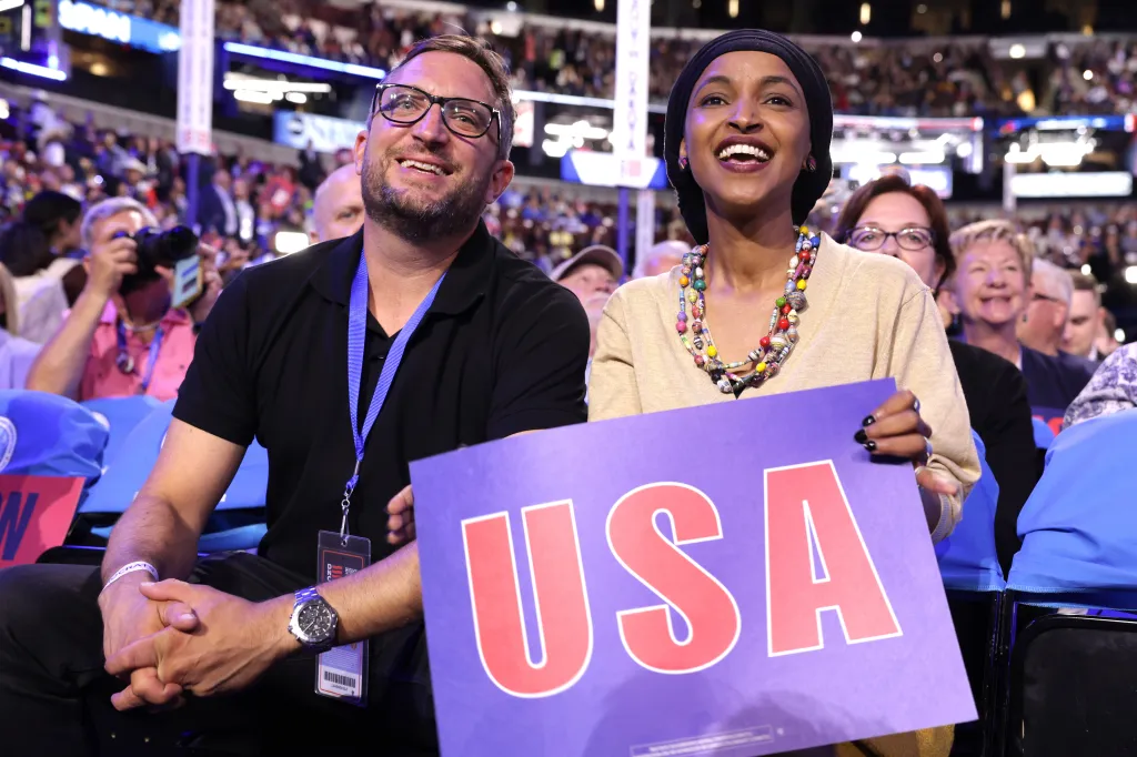 Rep. Ilhan Omar and her husband Tim Mynett smile while attending the Democratic National Convention.