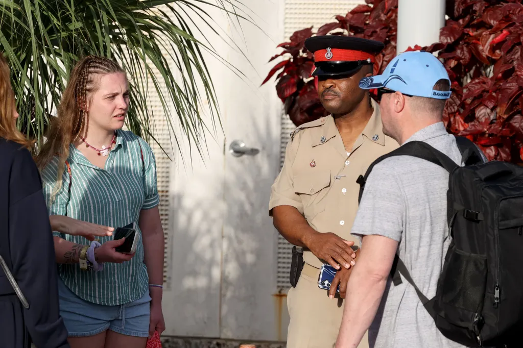 Karli Aylesworth speaking with a police officer while Steven stands nearby in Marsh Harbour, Bahamas.