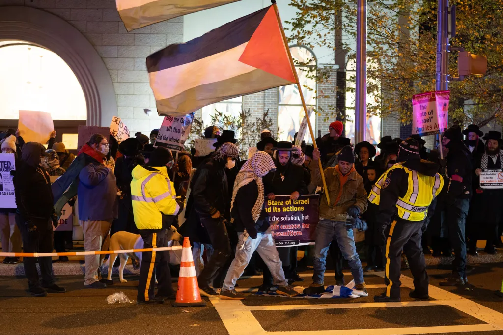 Police officers detain pro-Palestinian protesters outside a synagogue.