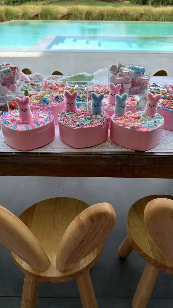 A table laden with Easter crafts and candy next to a pool.