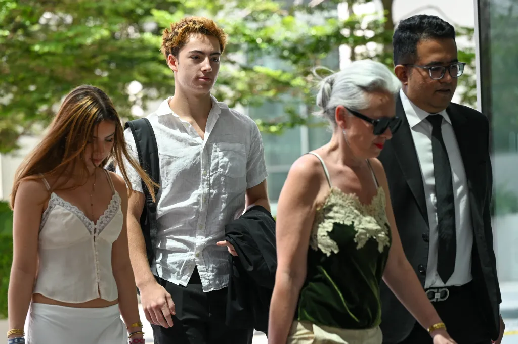 French teenager Didier Gaspard Owen Maximilien (2nd L) arrives for an application to leave jurisdiction, for the court's permission to leave Singapore, at the State Courts in Singapore on April 29, 2026. 