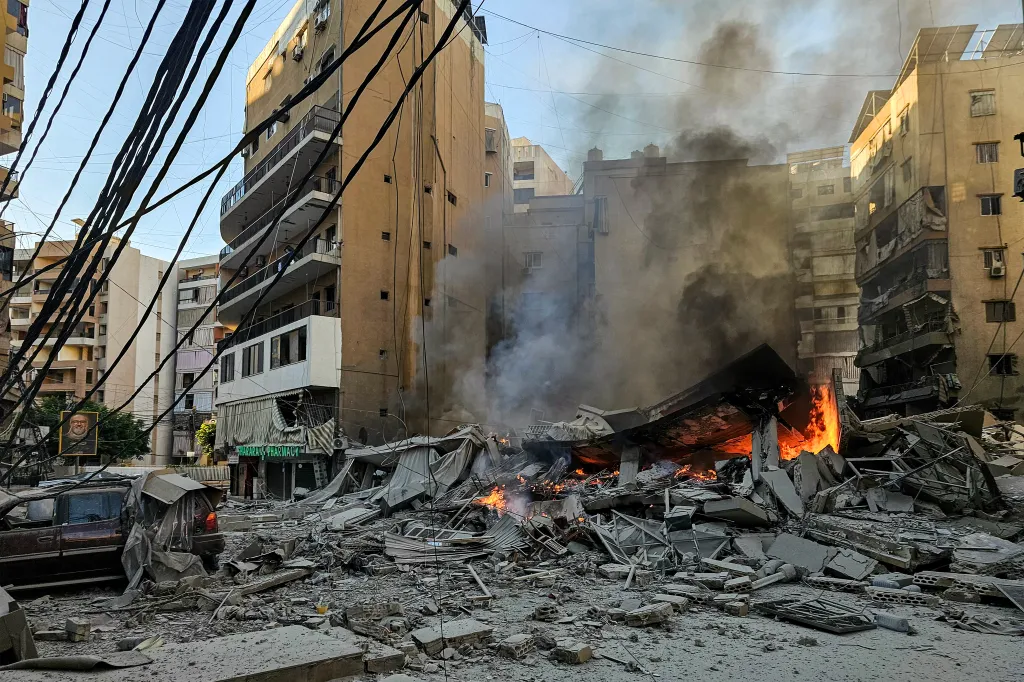 A fire burning at the site of a collapsed building following an Israeli airstrike on Beirut's southern suburbs.