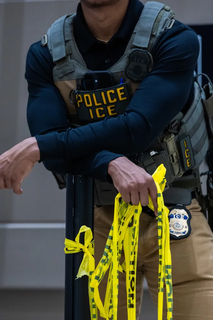 An ICE agent in tactical gear with 