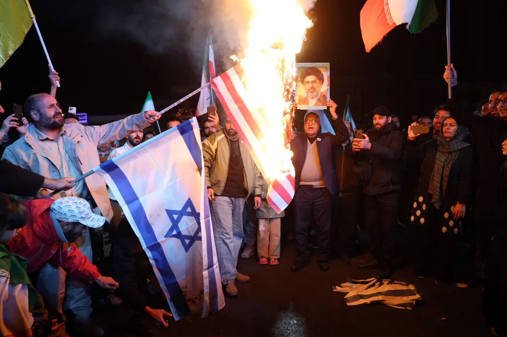 Iranians burning US and Israeli flags in Tehran following a US-Iran ceasefire announcement.
