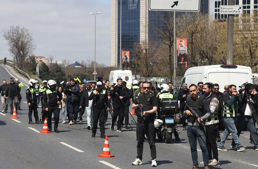 Police and civilians stand on a cordoned-off street in Istanbul after an attack on a building that previously housed the Israeli Consulate.