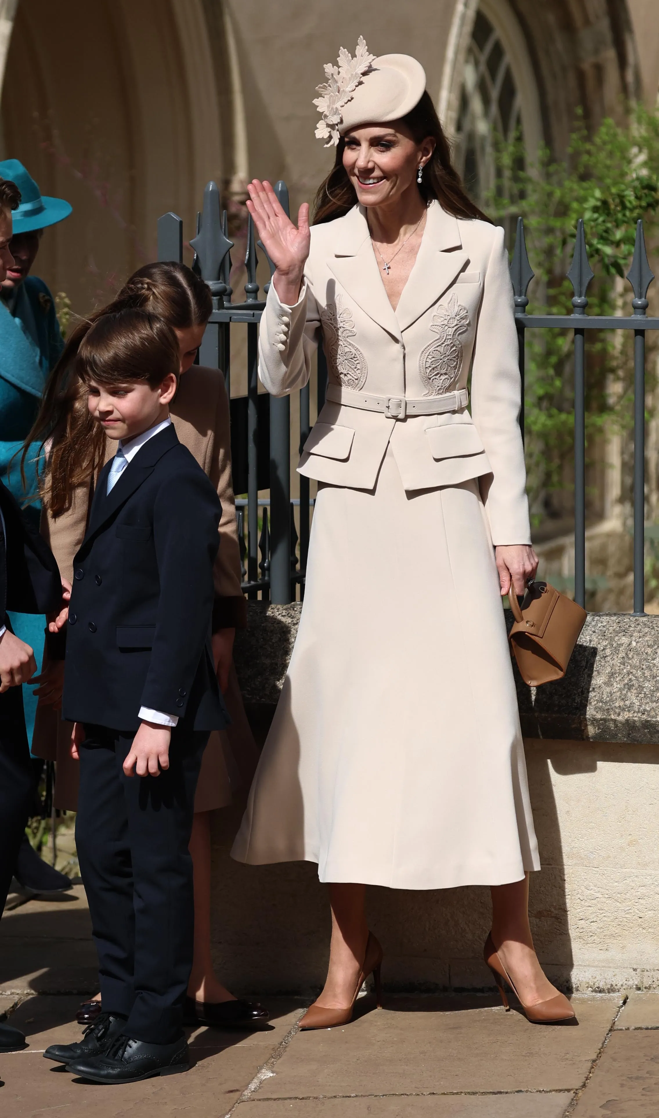 Princess Catherine waves while departing an Easter Sunday service with Prince Louis and other family members.
