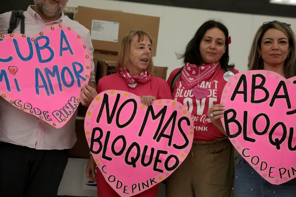Activists Medea Benjamin, Jazmin Rumbaut, and Michelle Ellner holding heart-shaped 