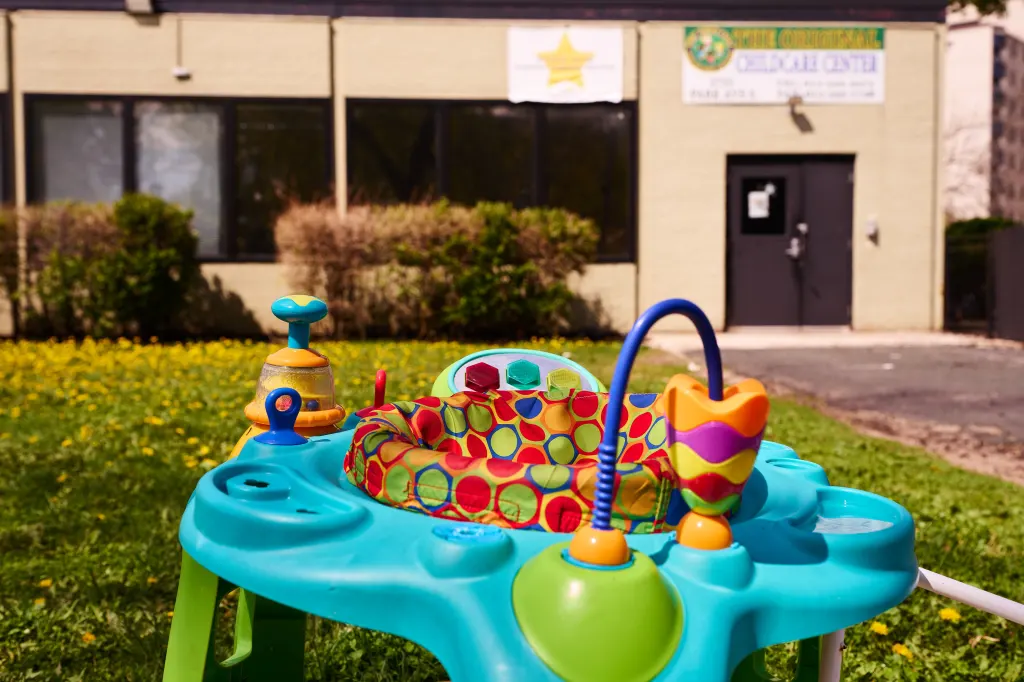 An infant stationary play station sits outside The Original Childcare Center.