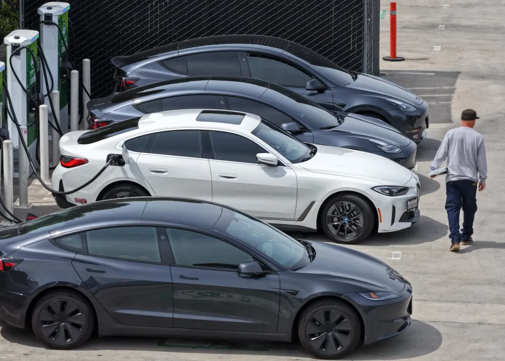 An aerial view of electric cars charging at a Power Up Pasadena charging station, with a person walking away from the cars.