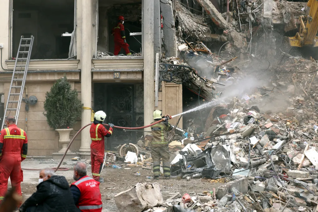 Firefighters douse the rubble of a destroyed residential building in Tehran.