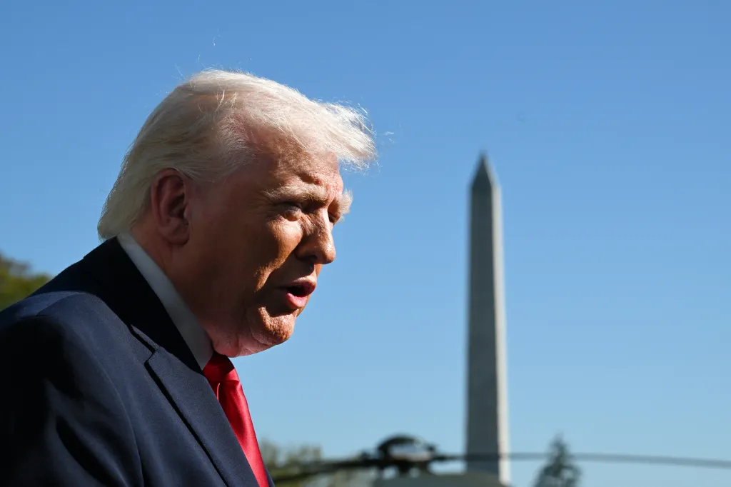 President Donald Trump speaking to the media before departing the White House with the Washington Monument in the background.